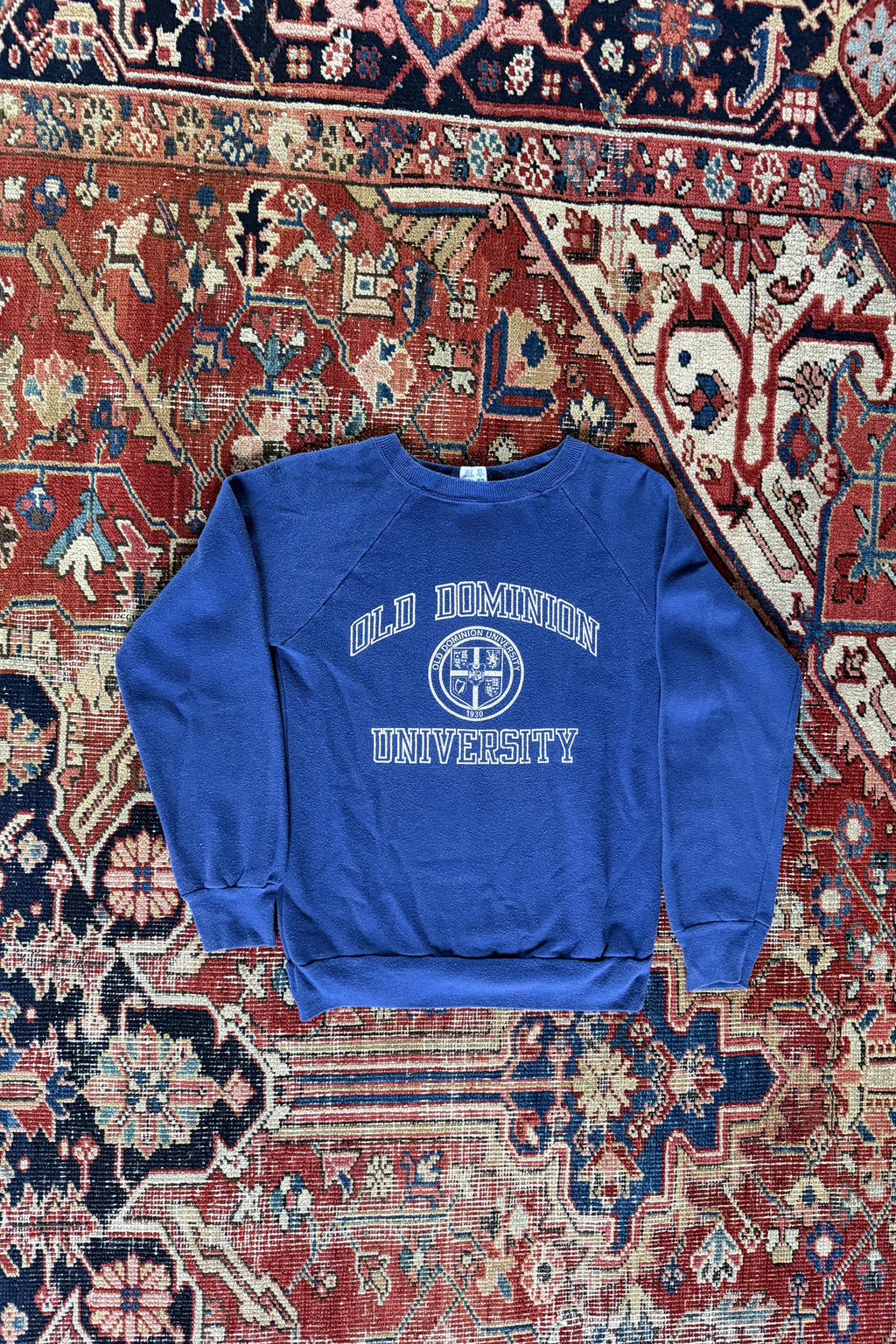 Vintage navy blue Champion Old Dominion University crewneck sweatshirt with collegiate lettering on patterned rug.