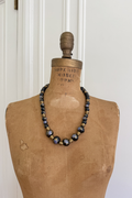 1930s Art Deco black glass wedding cake bead necklace styled on a vintage mannequin.