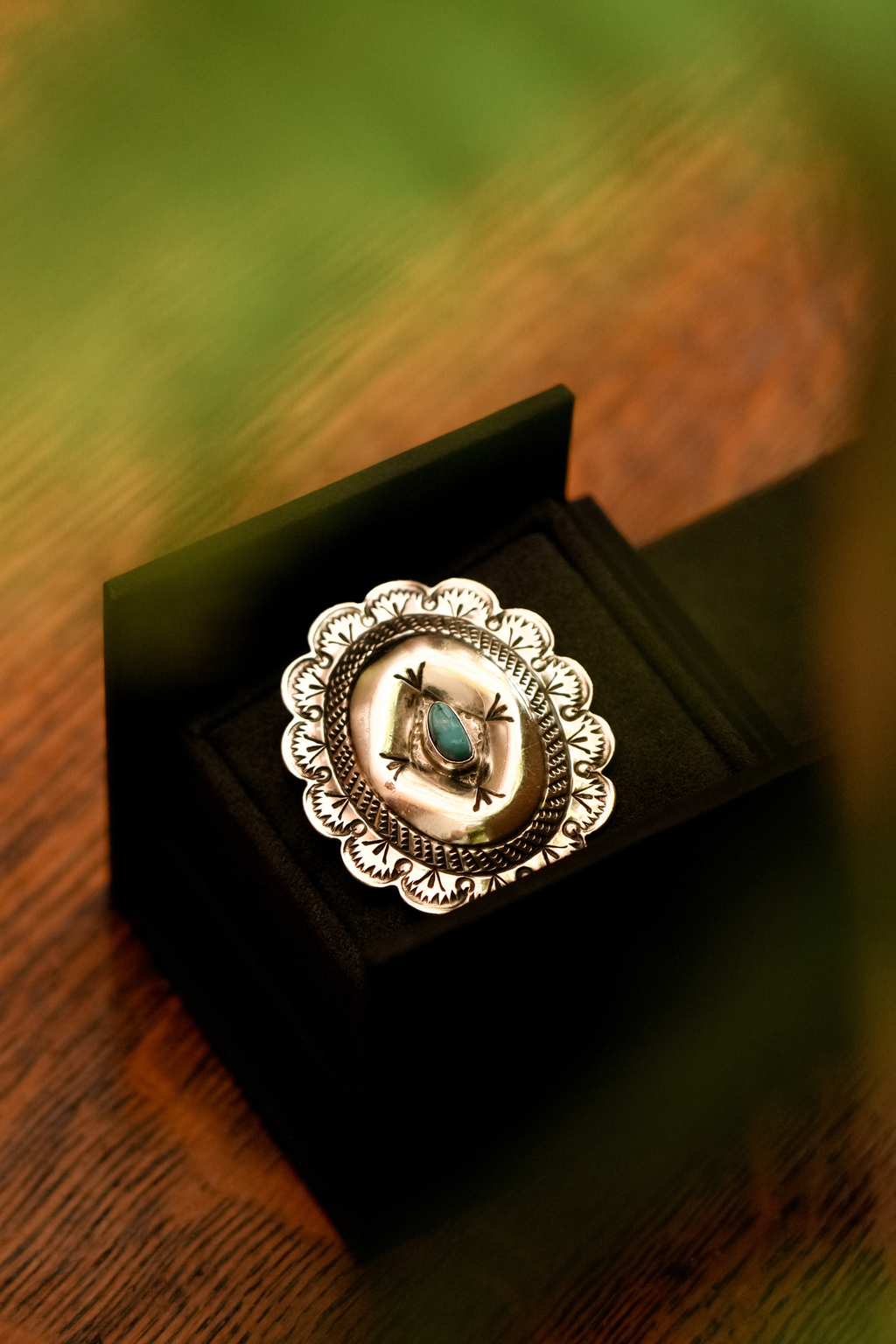 Vintage Southwestern hand-stamped silver concho with turquoise stone
