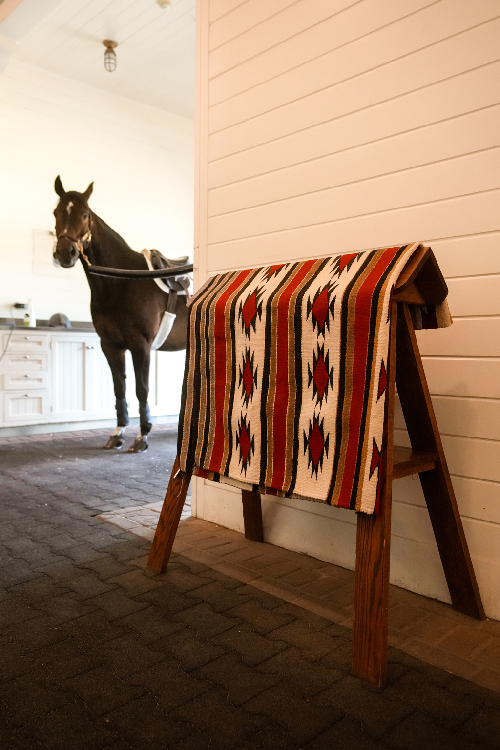Large antique Southwestern wool rug in western horse barn 