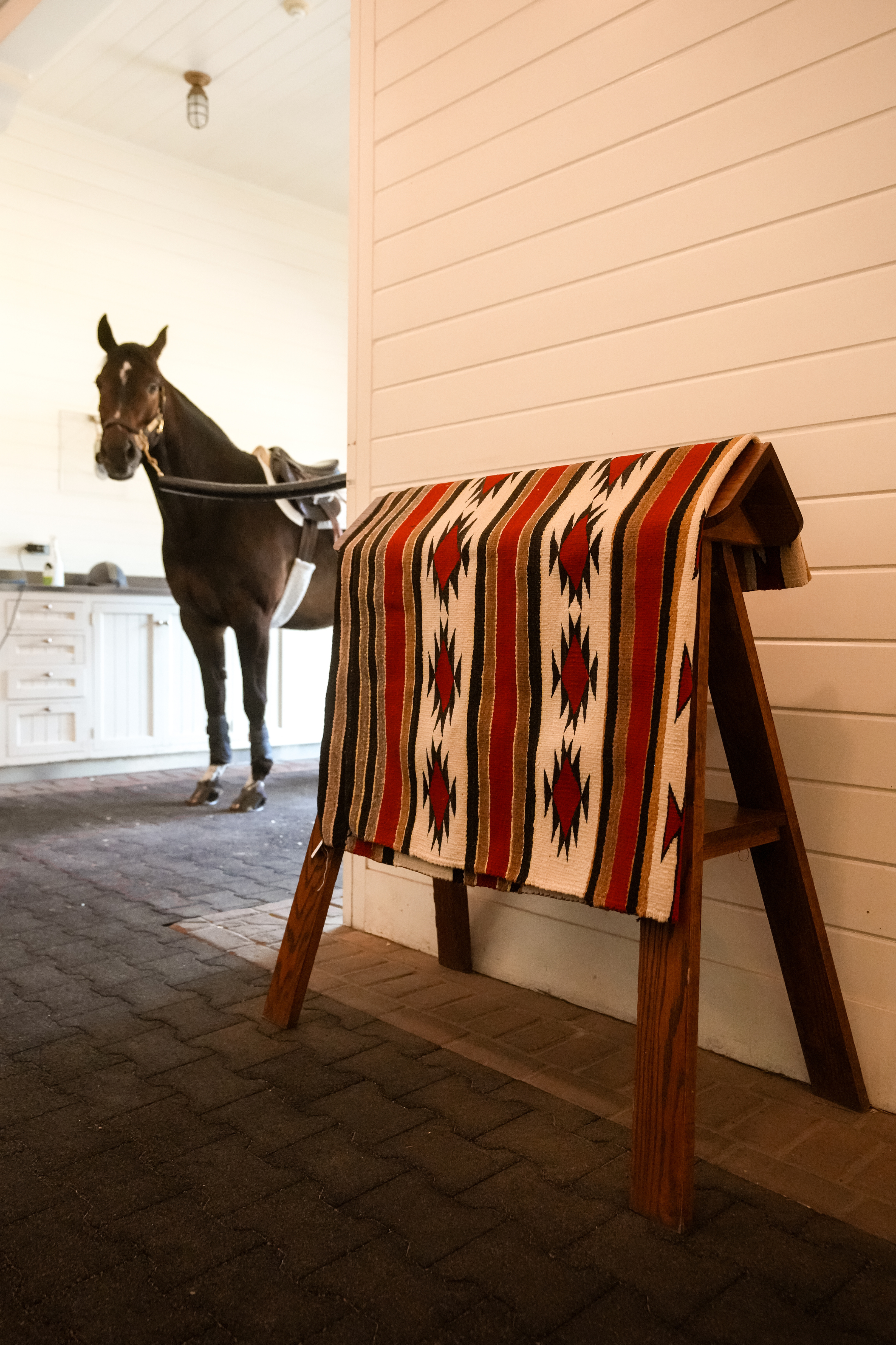 Large antique Southwestern wool rug in western horse barn 