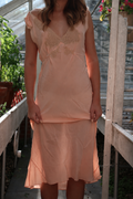 Authentic 1930s peach silk bias-cut slip dress with ecru lace appliqué and cap sleeves on model.